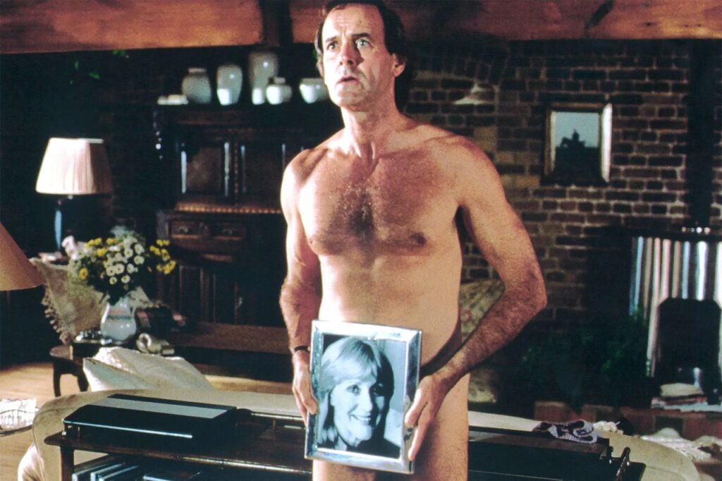 Archie Leach cerca di coprirsi con una fotografia in Un pesce di nome Wanda (1988).